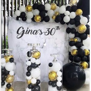 Over a hundred white, gold, and black balloons.